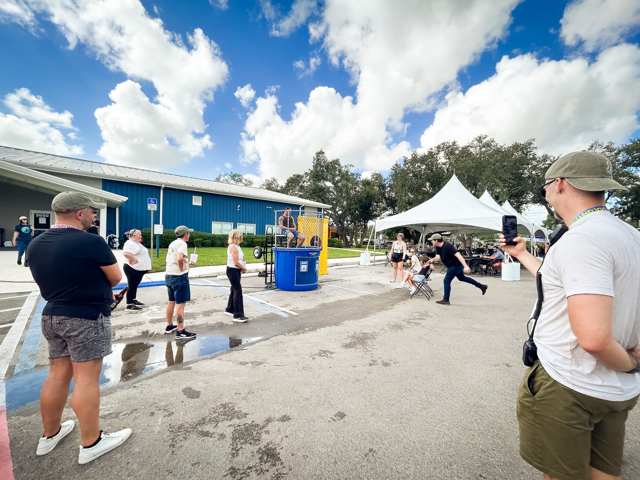 Group of people gather around dunk tank with Pastor Dan Minor pitching