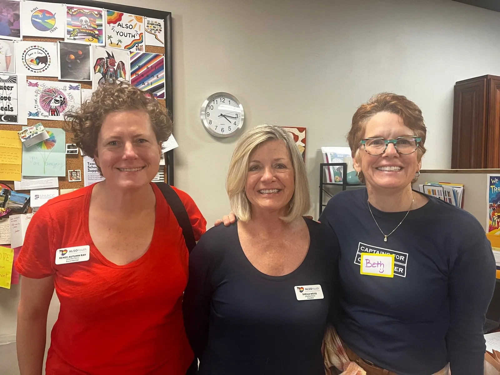 Three smiling volunteers wearing name tags.