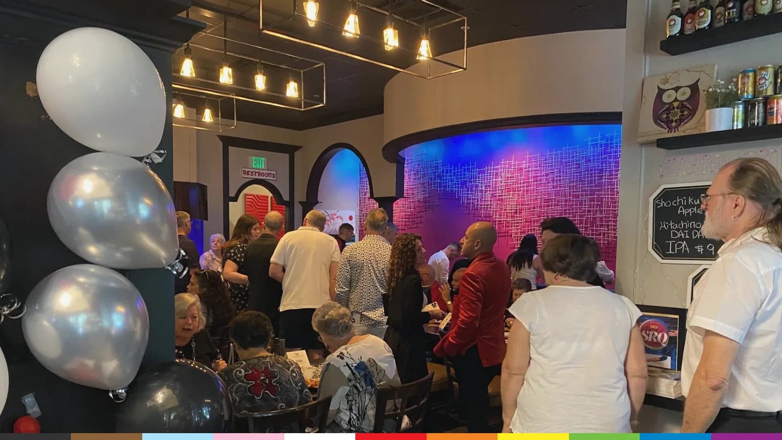 Guests fill Tsunami Sushi and Hibachi Grill for an ALSO Youth brunch benefit, with silver and black balloons by the door.